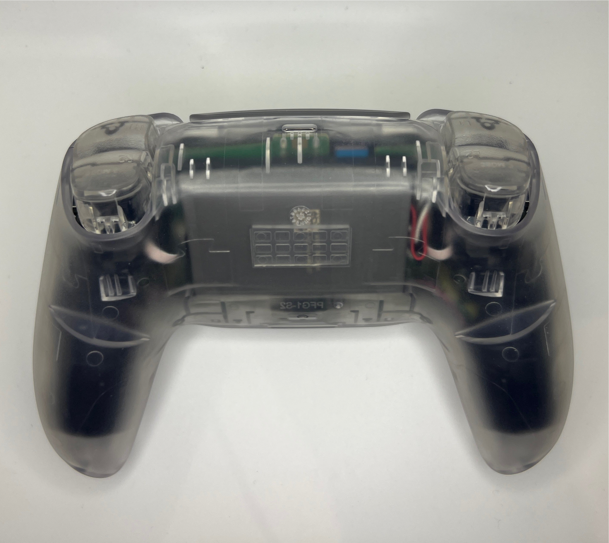 PS5 controller with transparent casing showing off transparent triggers on a white background