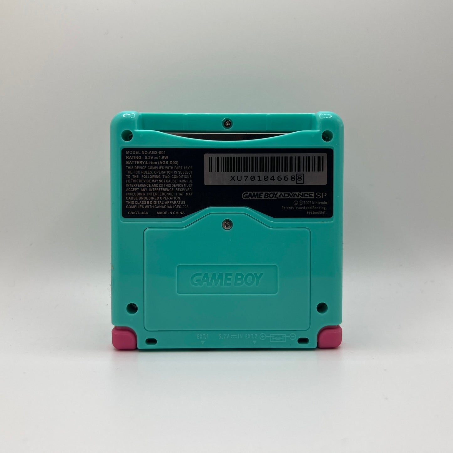 Teal Game Boy Advance SP with pink buttons on a white background