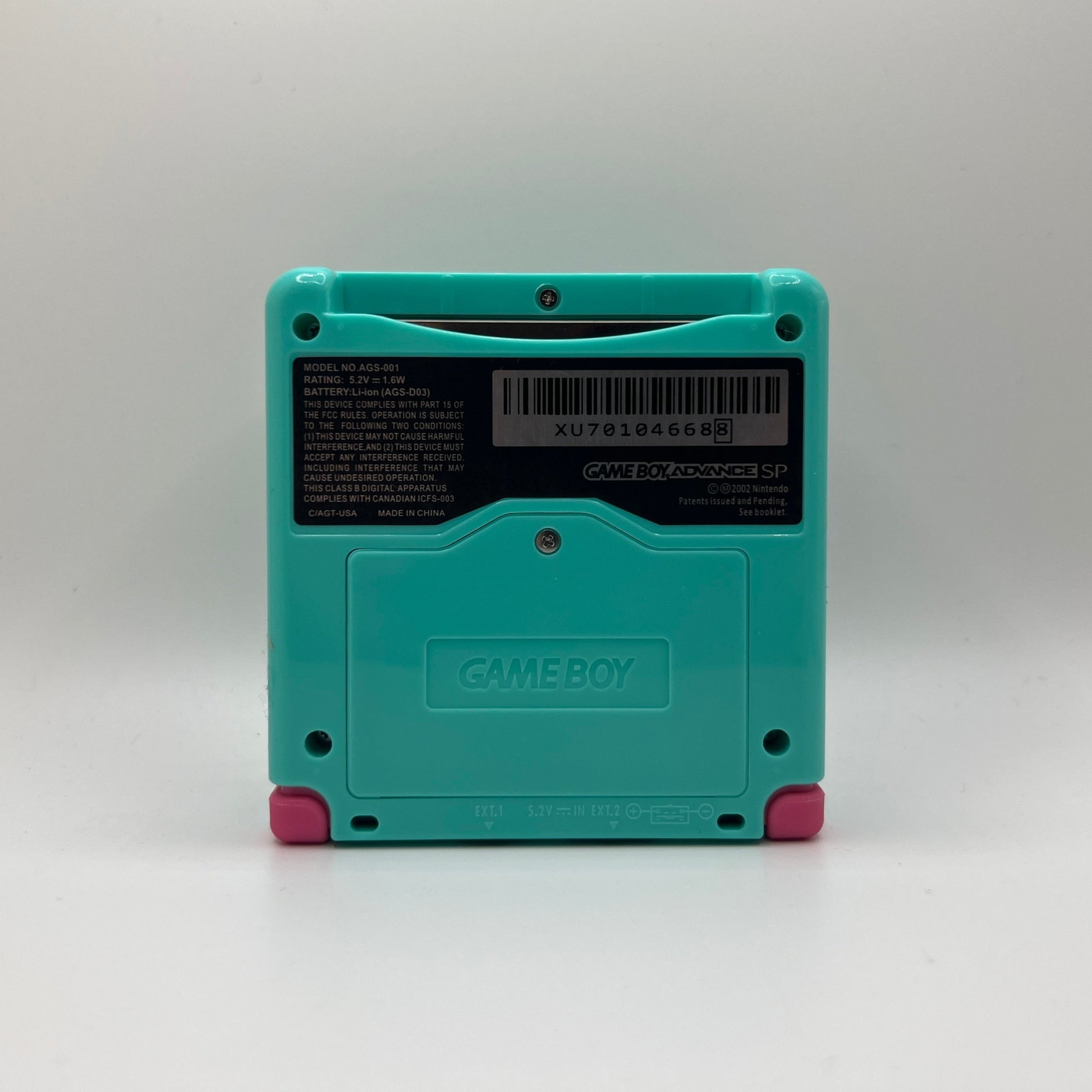 Teal Game Boy Advance SP with pink buttons on a white background