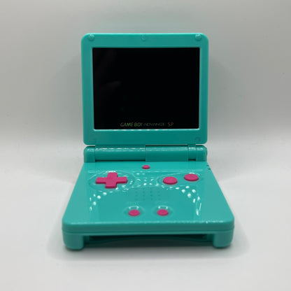 Teal Game Boy Advance SP with pink buttons on a white background