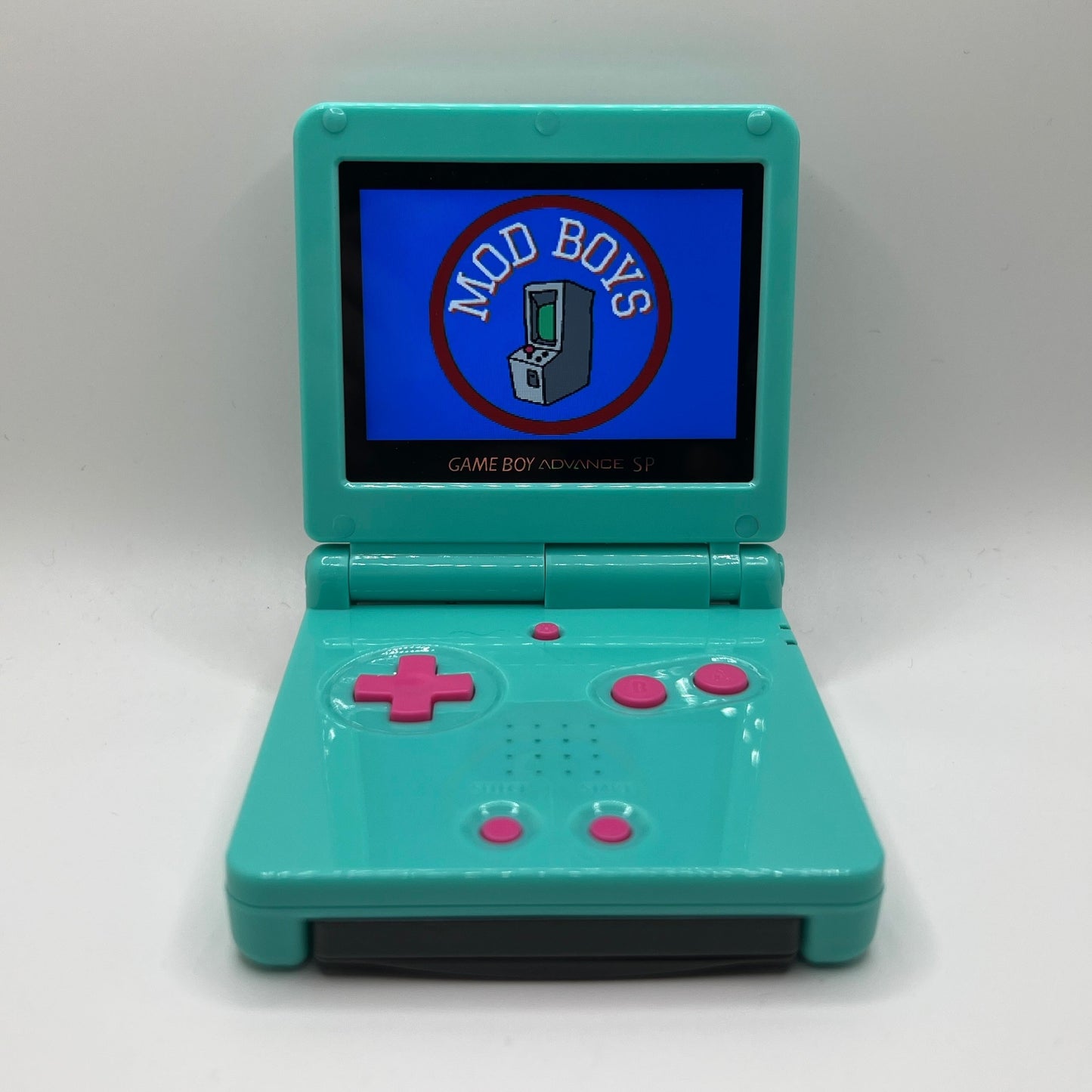Teal Game Boy Advance SP with pink buttons. The screen is displaying 'Mod Boys' logo on a white background